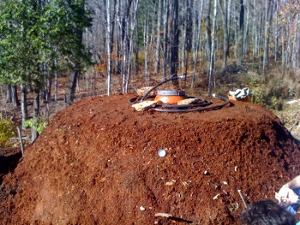 mound of wood mulch with mini biogas digester ready to start composting